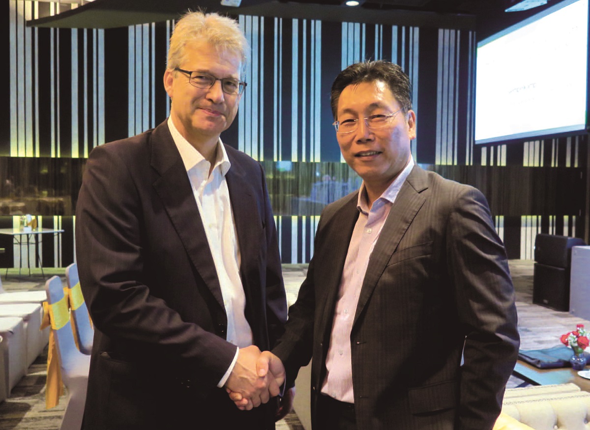 Handschlageinigung zur Vertragsunterzeichnung: (v. l. n. r.) Jürgen Philipps, Sprecher Siempelkamp- Geschäftsführung, David Huang, CEO Green River Panels